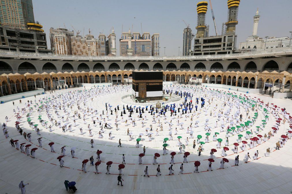 Peregrinos sostienen sombrillas de colores mientras circulan alrededor de la Kaabaen La Meca