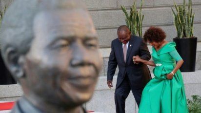 El presidente sudafricano Cyril Ramaphosa y la presidenta del parlamento Baleka Mbete pasan por delante de una estatua de Nelson Mandela en el parlamento sudafricano antes de una ceremonia, el 7 de febrero de 2019 en Ciudad del Cabo