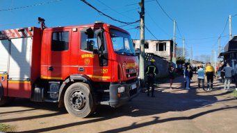 Los bomberos y la vivienda de dos piso atrás, donde fueron hallados la mujer y su hija. Foto: Sebastián Giovanelli, Subrayado.