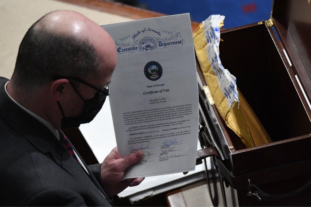 Un hombre sostiene el certificado de voto del estado de Nevada.