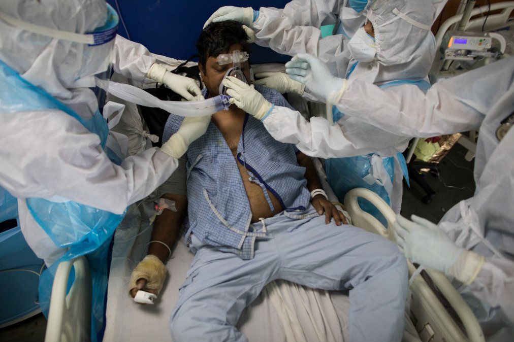 Doctores y enfermeras usando equipamiento protectivo cuidan a un paciente con Covid-19 en la Unidad de Cuidados Intensivos del Hospital de Sharda, en India, cerca de Nueva Delhi