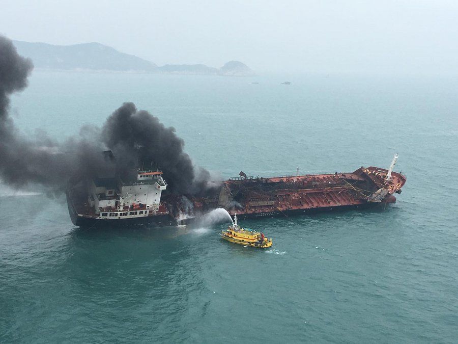 Un barco de bomberos lanza agua a un tanque de combustible encendido en llamas en la costa sur de Hong Kong.