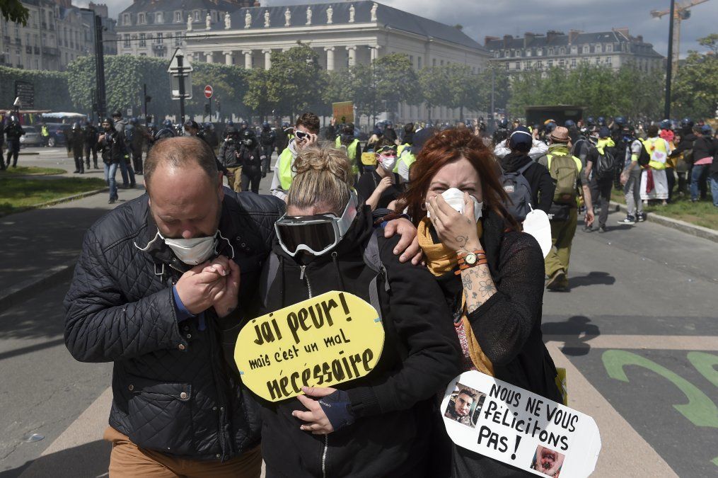 Manifestantes se protegen del gas lacrimógeno durante una protesta convocada por los chalecos amarillos en Francia