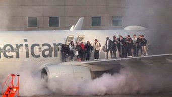 El avión con los pasajeros parados sobre una de la alas, esperando ser evacuados por personal de emergencia. Foto: AFP.