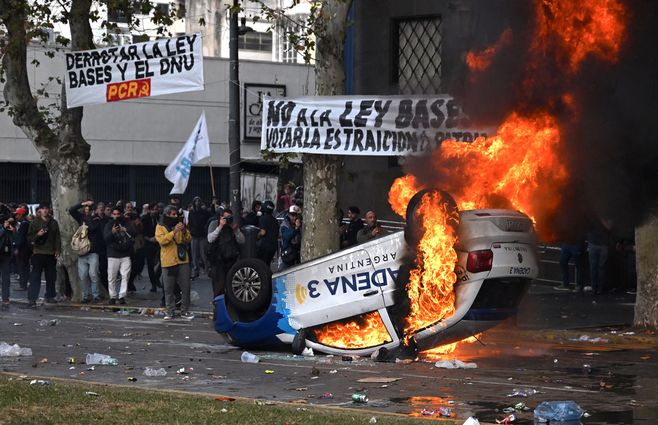 Foto: Tomás Cuesta / AFP. Manifestantes incendian el auto de un medio de comunicación, en Buenos Aires, el 12 de junio de 2024.